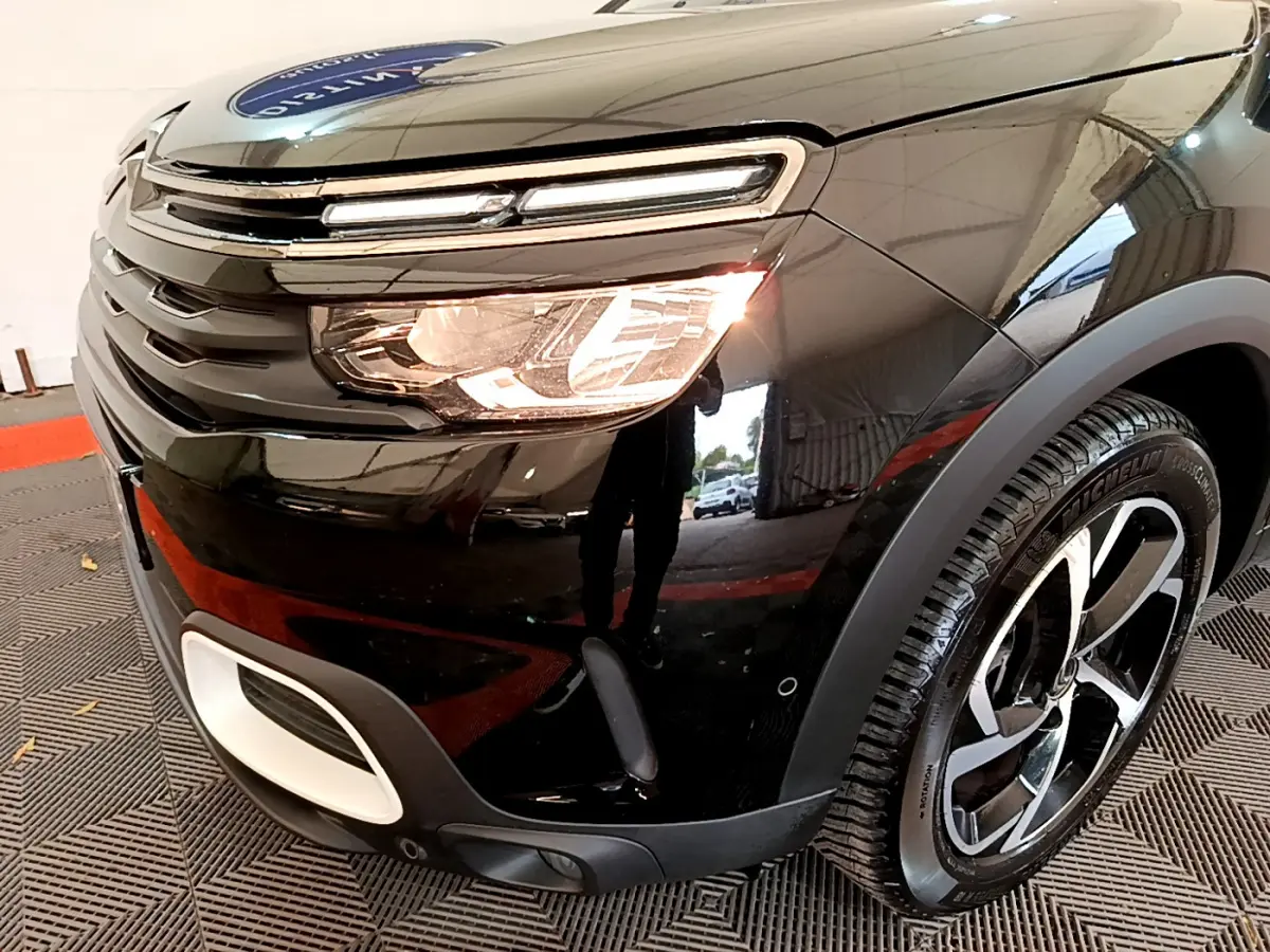 Gros plan sur l'avant droit noir du Citroën C5 Aircross 2020 avec phares allumés et jante alliage distinctive.