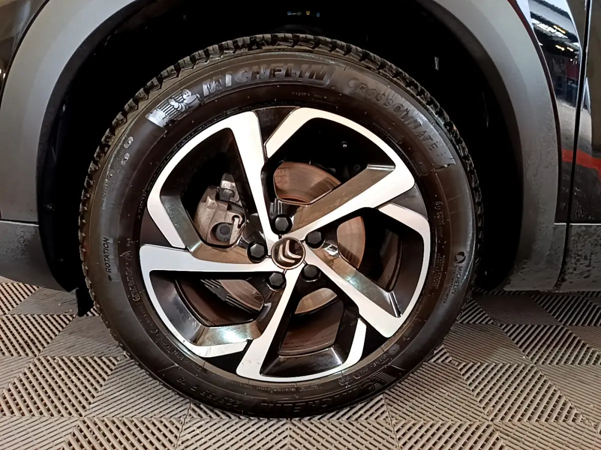 Gros plan sur la roue avant droite noire du Citroën C5 Aircross avec jante alliage bicolore et pneu Michelin.