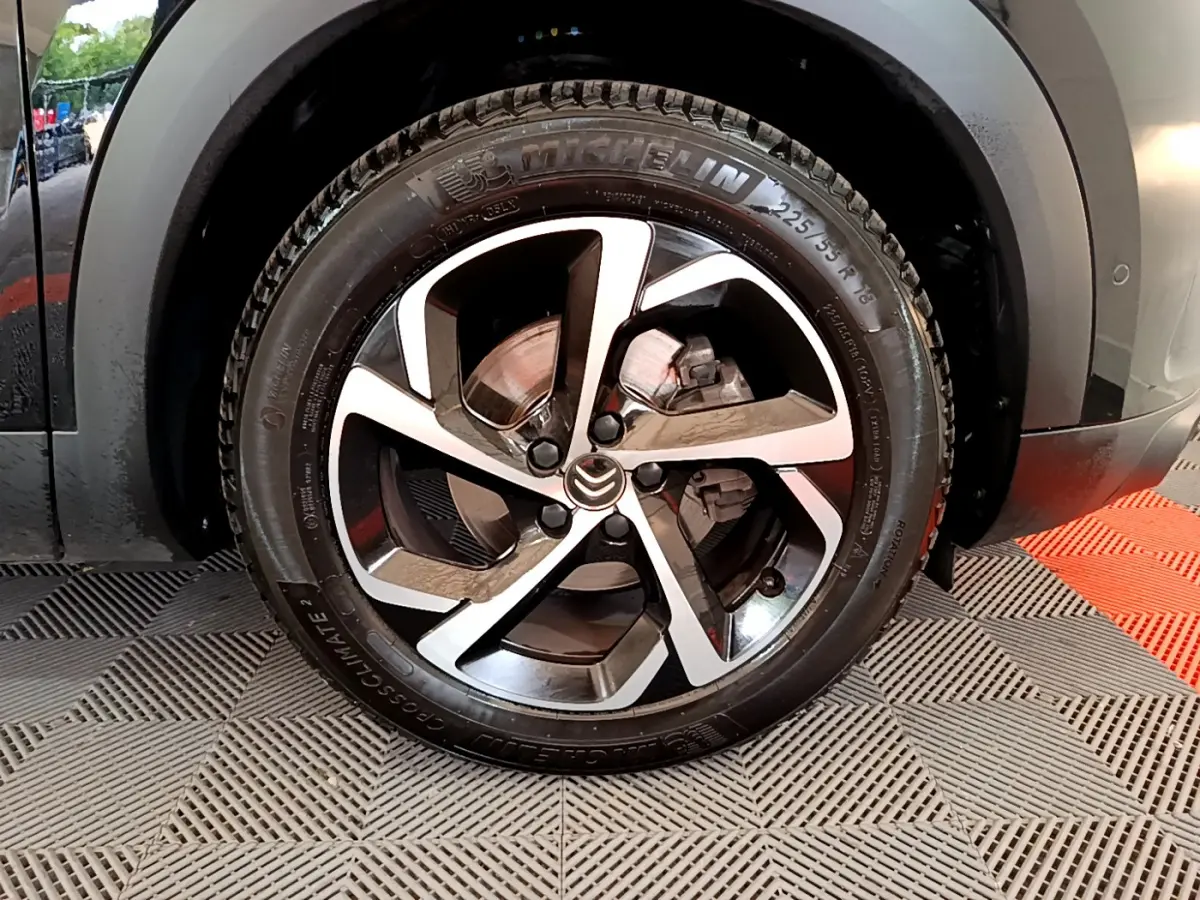 Gros plan sur la roue arrière droite d'un Citroën C5 Aircross noir, avec pneumatique Michelin visible et passage de roue gris.