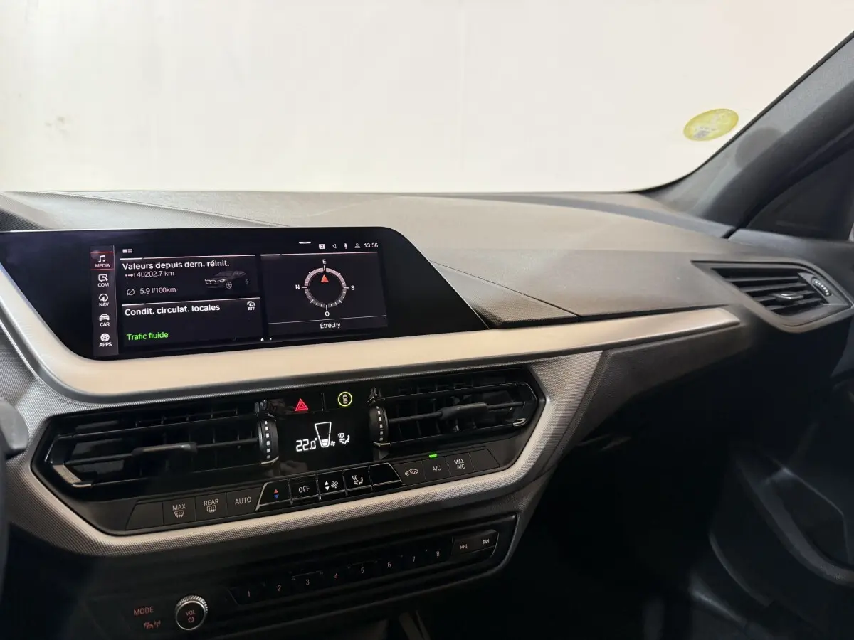 Tableau de bord intérieur de BMW Série 1 116d 2022, vue de côté droit avec écran tactile et commandes climatisation.
