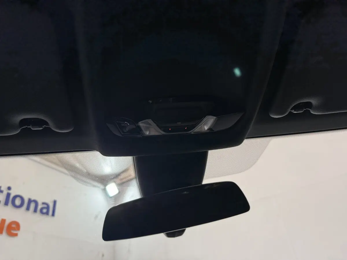 Vue intérieure du rétroviseur central et du plafonnier noir avec commandes SOS de la BMW Série 1 116d 2022.