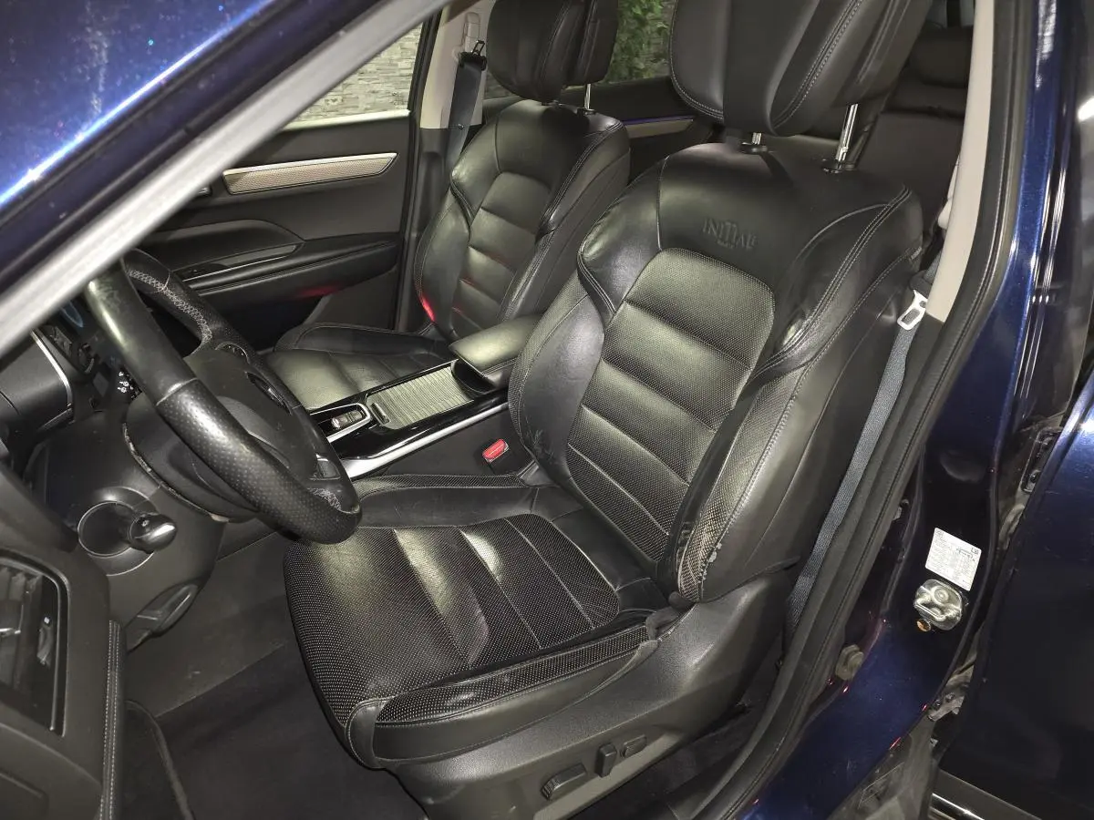 Vue intérieure côté conducteur du Renault Koleos bleu, sièges cuir Nappa noirs avec logo Initiale brodé.