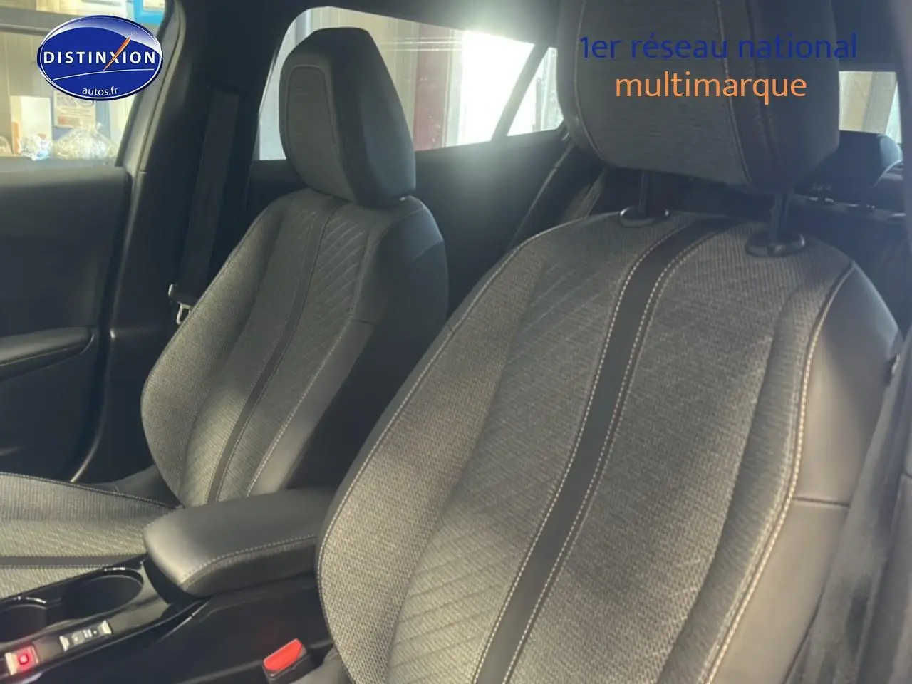 Vue intérieure rapprochée des sièges avant en tissu gris embossé avec surpiqûres contrastées d'un Peugeot 2008 2025.