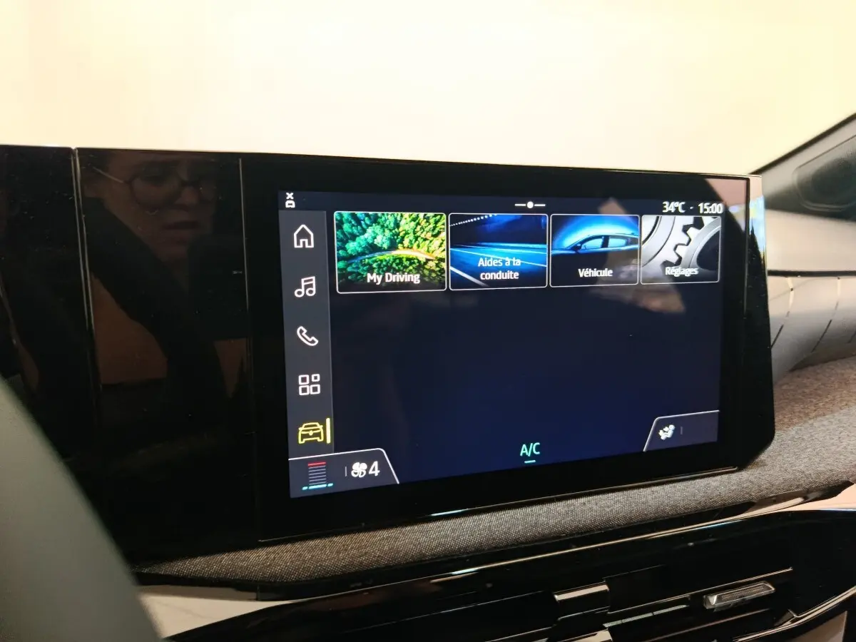 Écran tactile central affichant les options de conduite dans l’habitacle d’une Renault Clio bleu, vue intérieure.