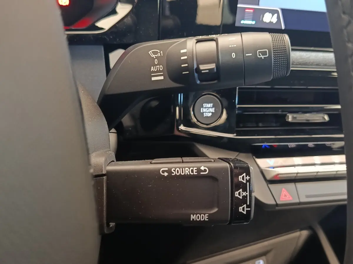 Gros plan sur la commande multifonctions et le bouton Start Engine Stop du tableau de bord intérieur de la Renault Clio bleu.