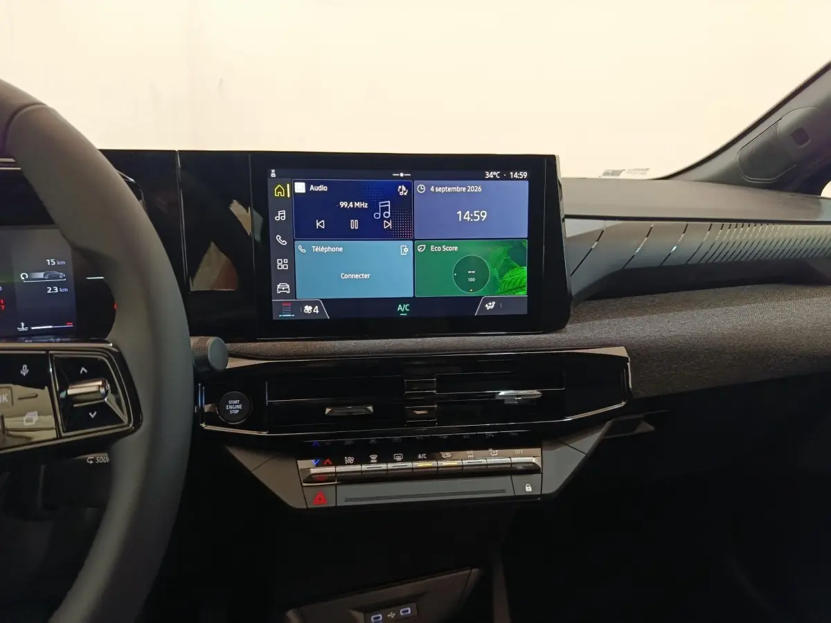 Vue intérieure du tableau de bord de la Renault Clio 2026, écran tactile central et volant multifonctions partiel visible.