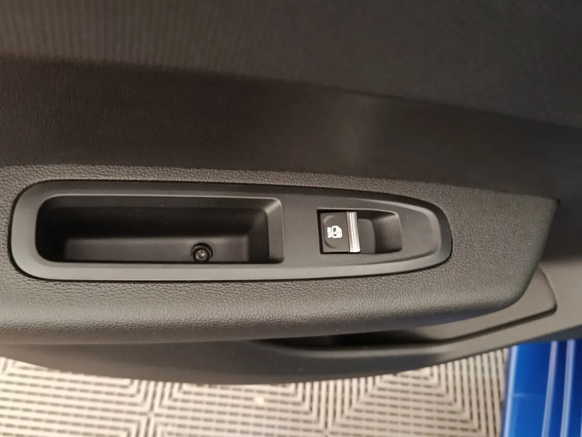 Détail de la commande de verrouillage des portes sur la portière côté gauche d'une Renault Clio bleu 2026.