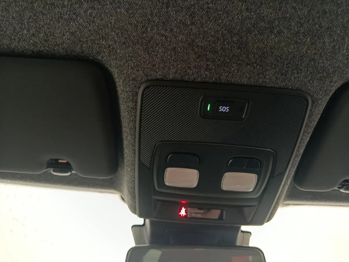 Vue intérieure du plafond de la Renault Clio bleu 2026, montrant les commandes d’éclairage et le bouton SOS éclairé.