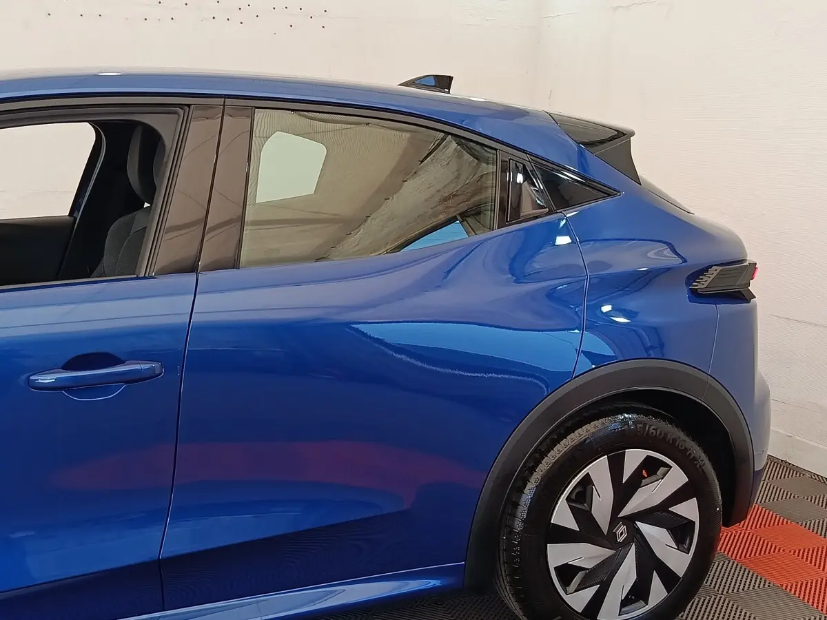 Profil côté gauche de la Renault Clio bleu 2026 avec jante au design géométrique et poignées de porte intégrées.