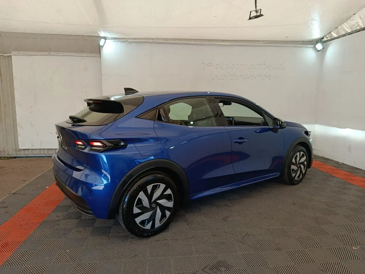 Vue 3/4 arrière droite d'une Renault Clio bleu 2026 avec feux arrière LED et jantes au design moderne.