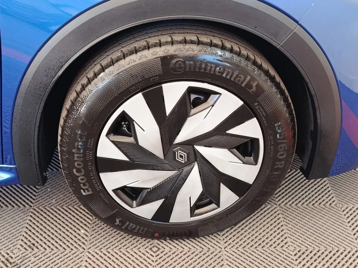 Gros plan sur la roue avant droite d’une Renault Clio bleu 2026 avec jante au design géométrique noir et argent.