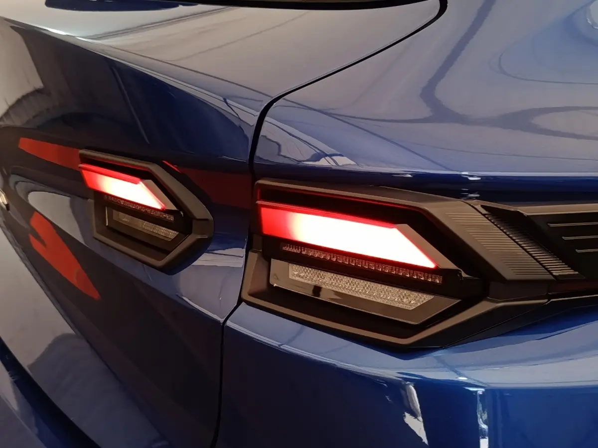 Gros plan sur les feux arrière LED rouges du côté gauche d’une Renault Clio bleu intense, modèle 2026.