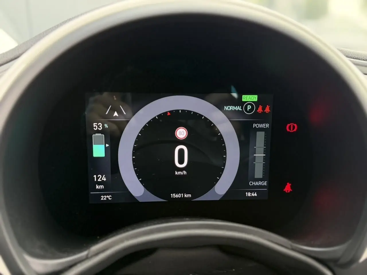 Vue rapprochée du tableau de bord numérique de la Fiat 500 électrique blanche, affichant la vitesse à 0 km/h et l'autonomie à 124 km.