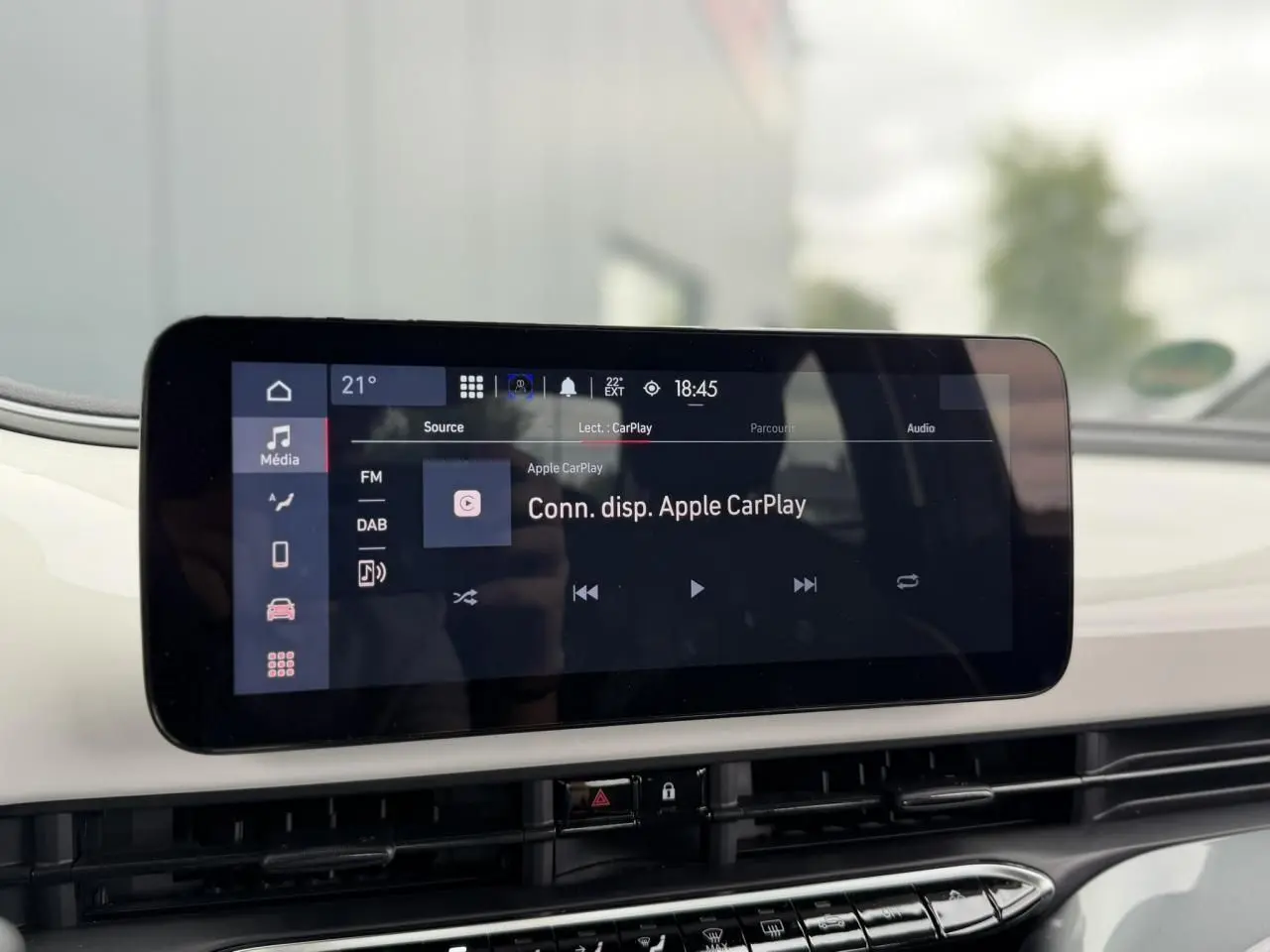 Écran tactile central affichant la connexion Apple CarPlay dans l’habitacle blanc d’une Fiat 500 électrique 2023.