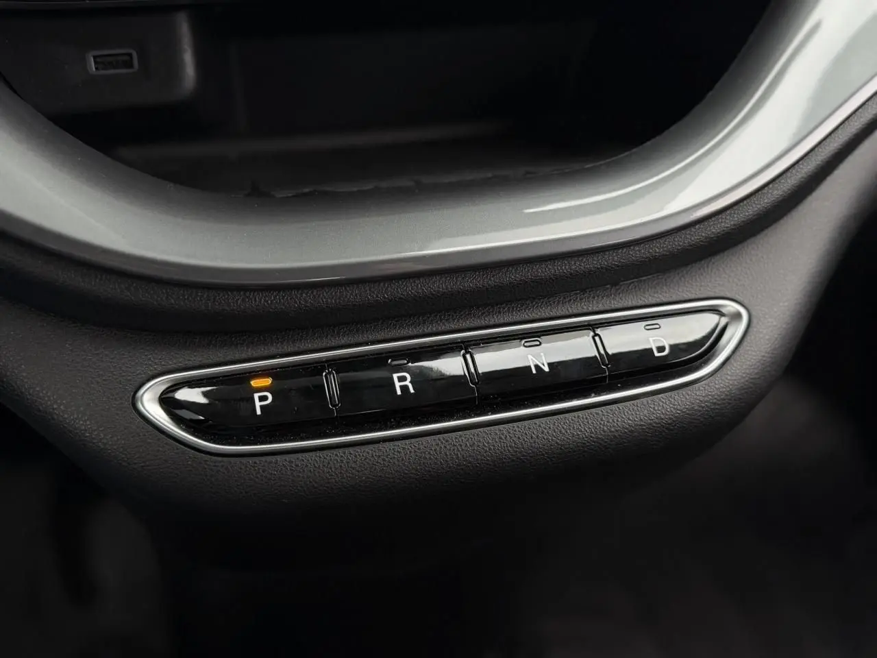 Gros plan sur la commande de boîte automatique noire avec indication orange sur "P" dans une Fiat 500 électrique blanche.
