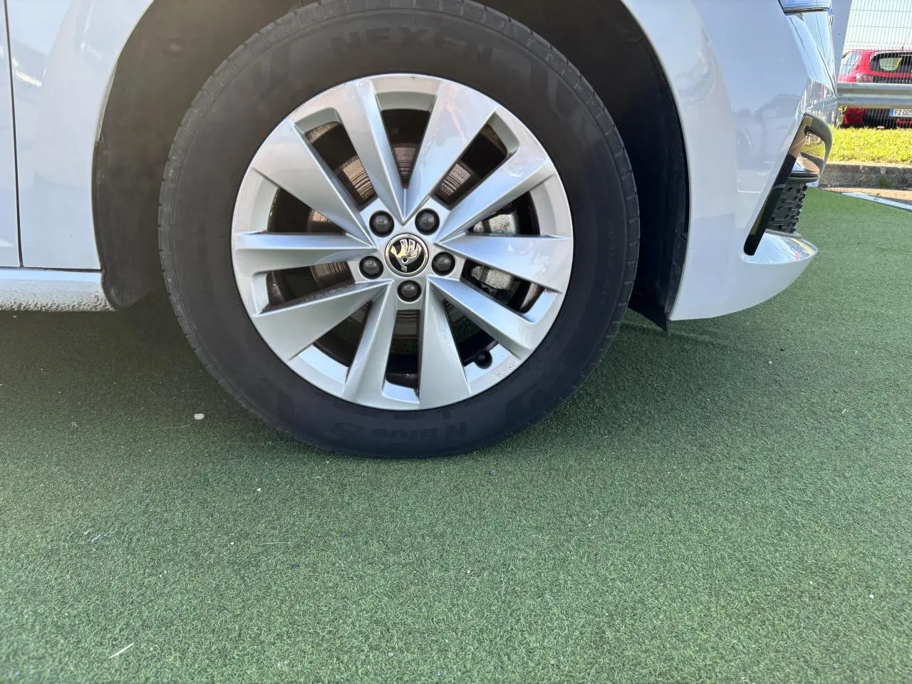 Gros plan sur la roue avant droite d'une Skoda Scala blanc glacier avec jante alliage 16 pouces Sargas Aero.