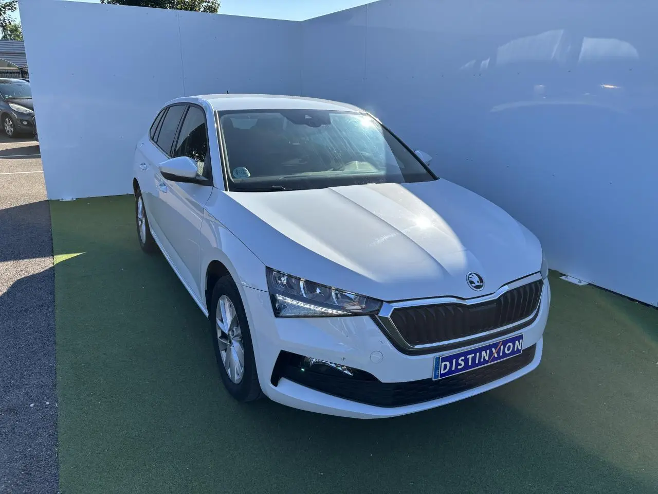 Vue 3/4 avant d'une Skoda Scala blanche Glacier avec calandre noire et jantes alliage argentées.