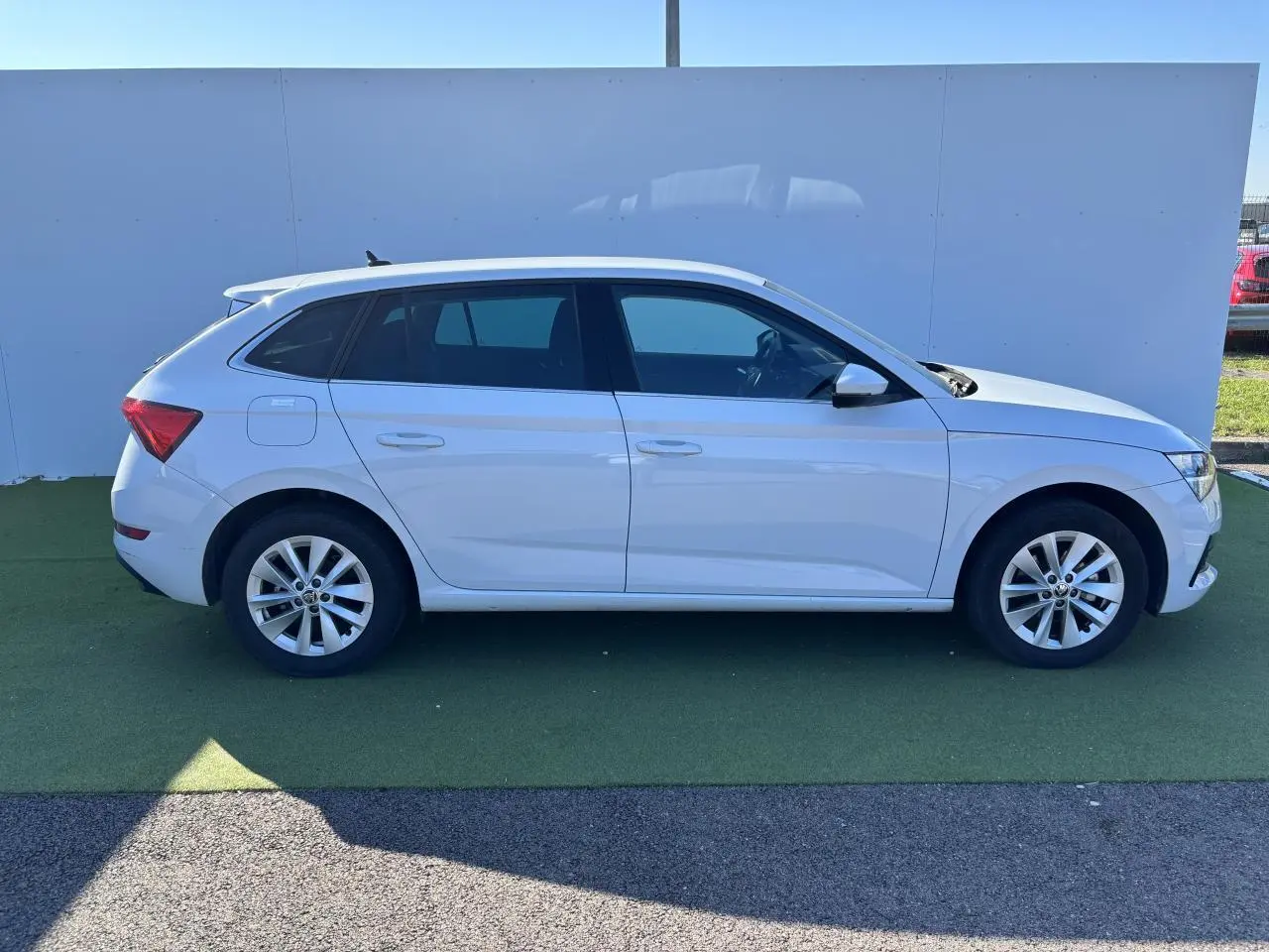 Profil côté droit d'une Skoda Scala blanc glacier 2024 avec jantes alliage 16 pouces sur fond neutre extérieur.