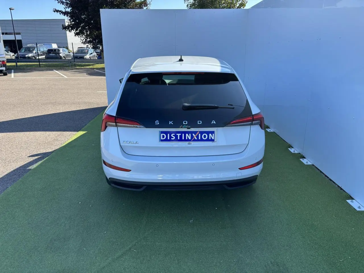 Vue arrière d'une Skoda Scala blanc glacier 2024 avec feux arrière LED et plaque Distinxion.