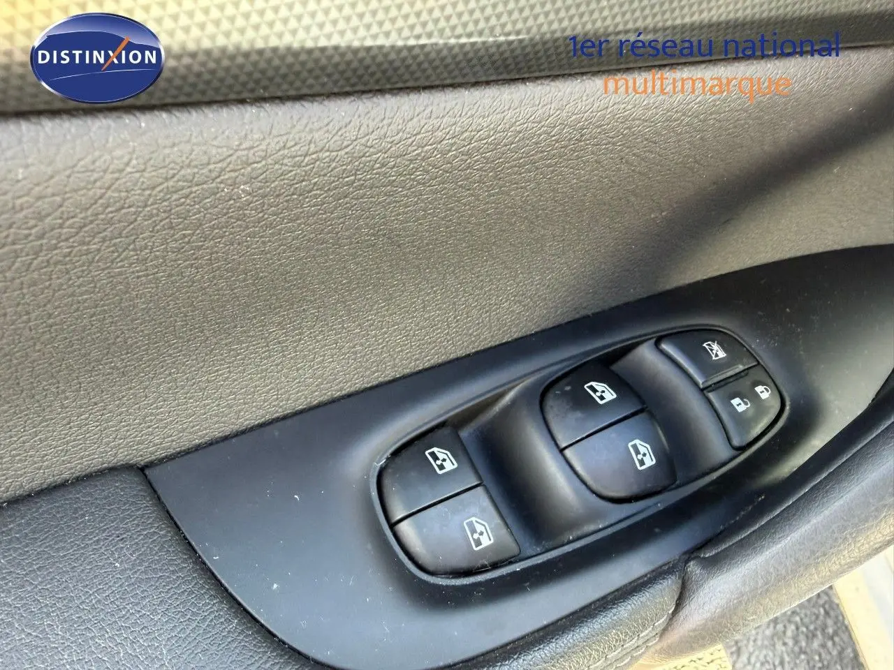 Gros plan sur les commandes des vitres électriques et verrouillage sur la portière côté gauche d’un Nissan Qashqai blanc nacré.