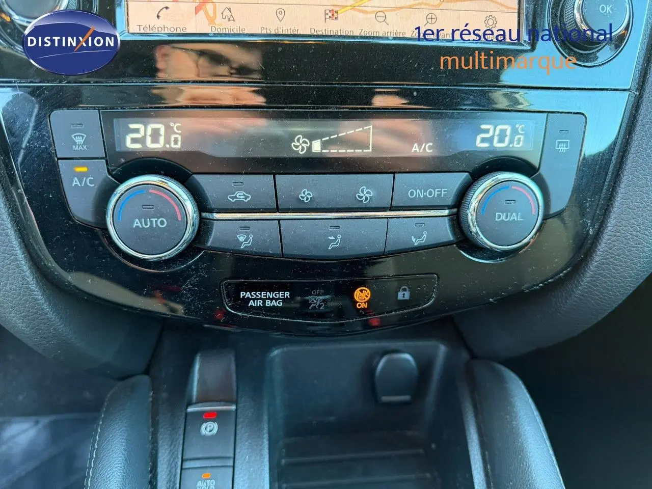 Vue rapprochée du tableau de bord du Nissan Qashqai 2019, montrant la climatisation automatique avec affichage digital à 20°C.