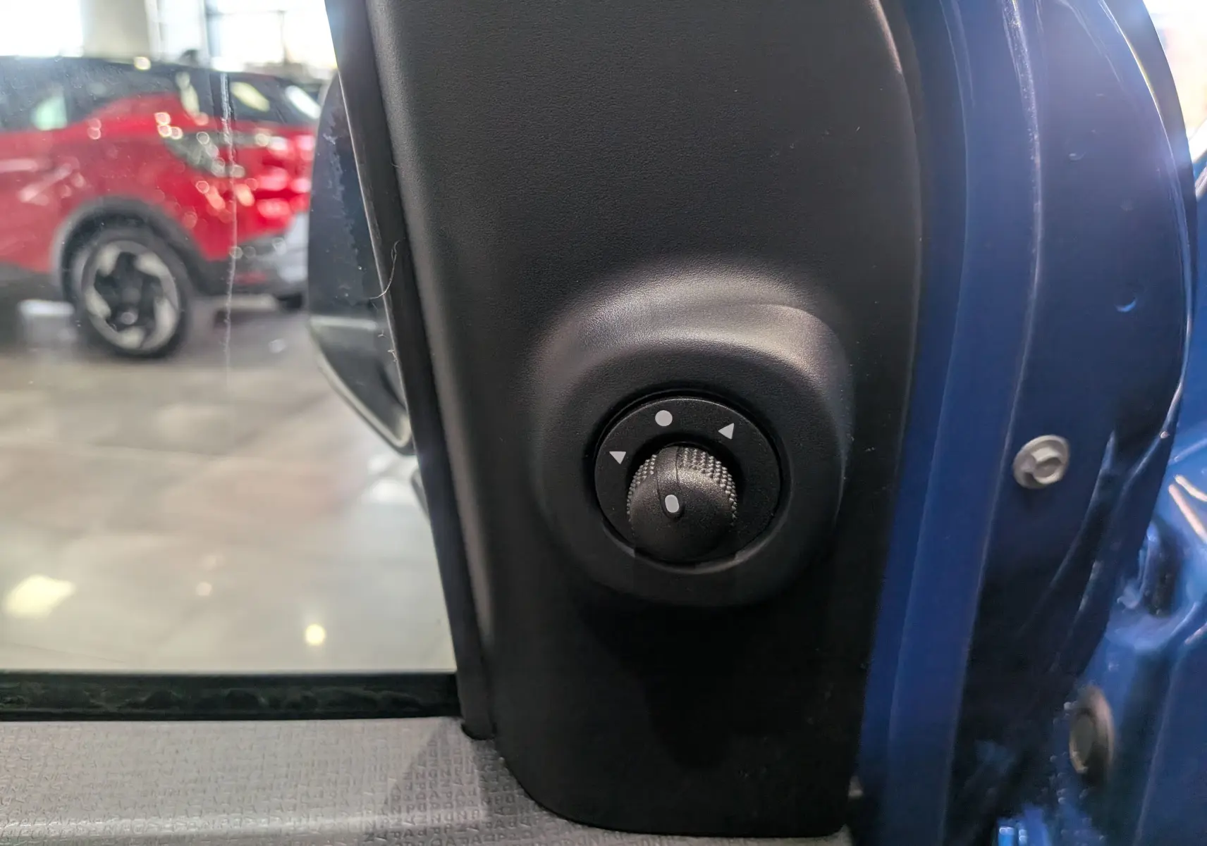 Gros plan sur le bouton de réglage des rétroviseurs côté gauche de la Fiat Panda 1.0 Hybrid Bleu Italia 2025.