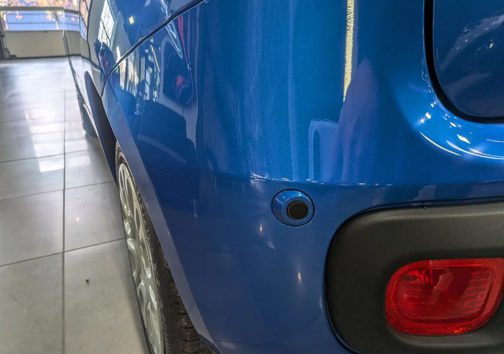 Gros plan sur l'arrière droit bleu Italia de la Fiat Panda 1.0 70 CH Hybrid City avec feu rouge et capteur de recul.