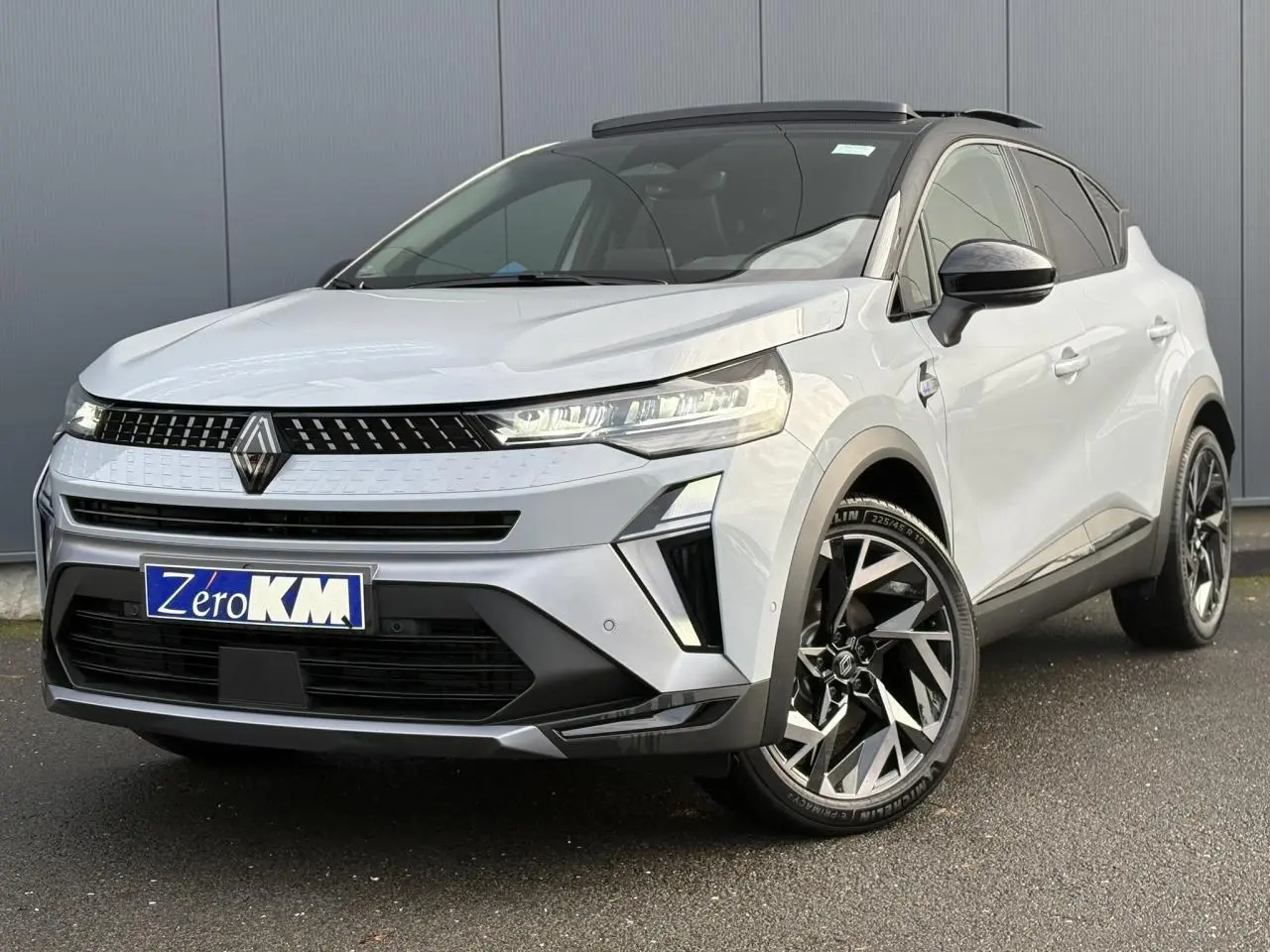 Vue 3/4 avant droit du Renault Captur gris clair avec toit noir et jantes alliage noires et argentées.