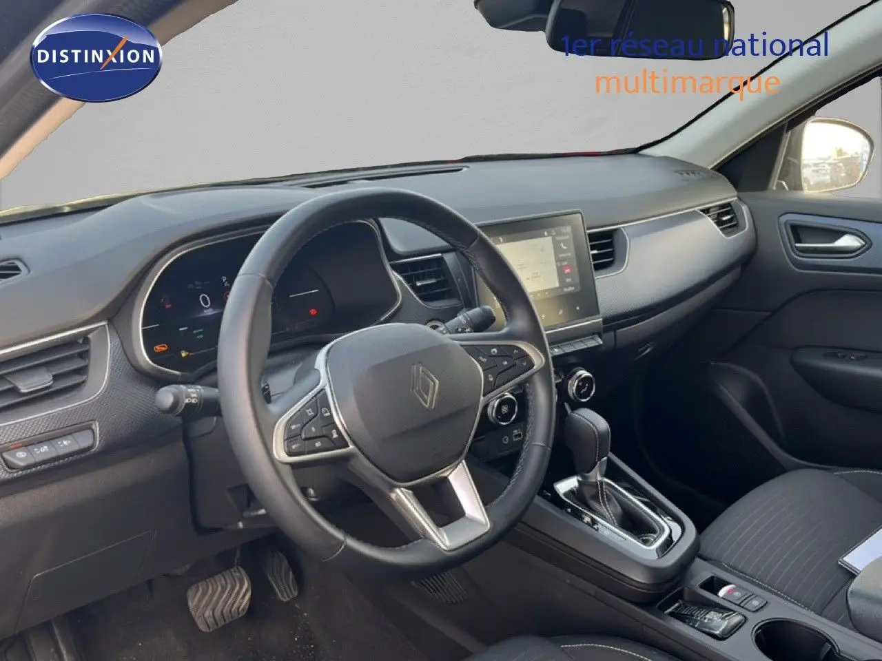 Vue intérieure du poste de conduite du Renault Arkana 2025, avec volant multifonction et console centrale en noir.