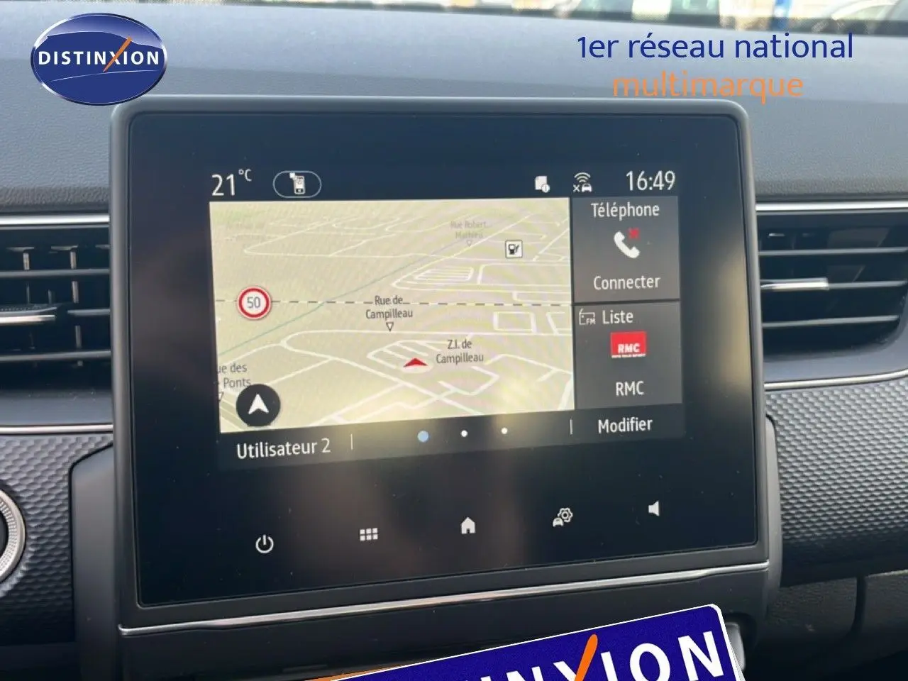 Vue rapprochée de l’écran tactile central du Renault Arkana gris Cassiopée Métal, affichant la navigation et les options connectées.
