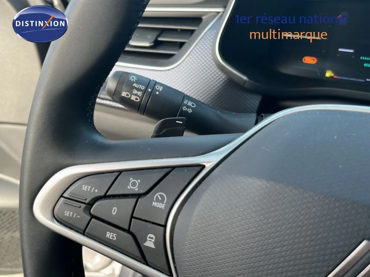 Gros plan sur les commandes au volant du Renault Arkana gris Cassiopée Métal, mettant en valeur les boutons multifonctions.