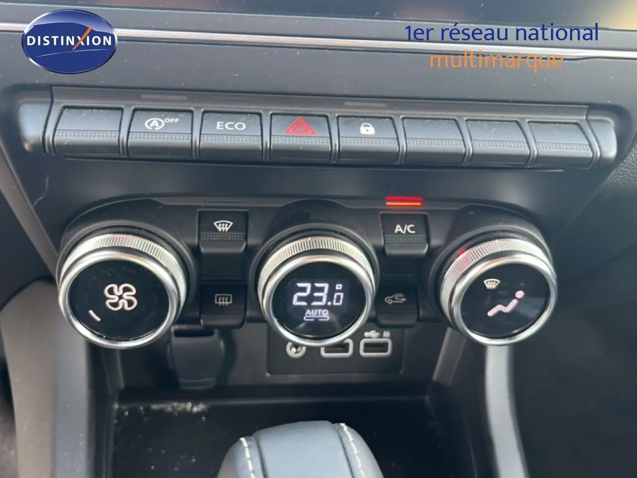 Détail du tableau de bord du Renault Arkana 2025 gris cassiopée, montrant les commandes de climatisation et boutons fonctionnels.