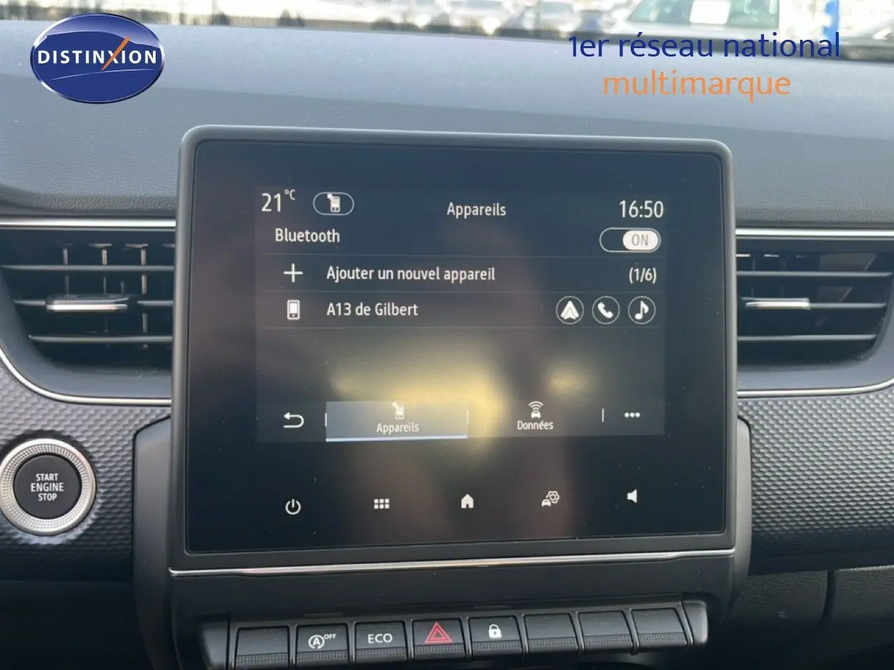 Écran tactile central du Renault Arkana gris Cassiopée métal, vue frontale du tableau de bord avec bouton start visible à gauche.