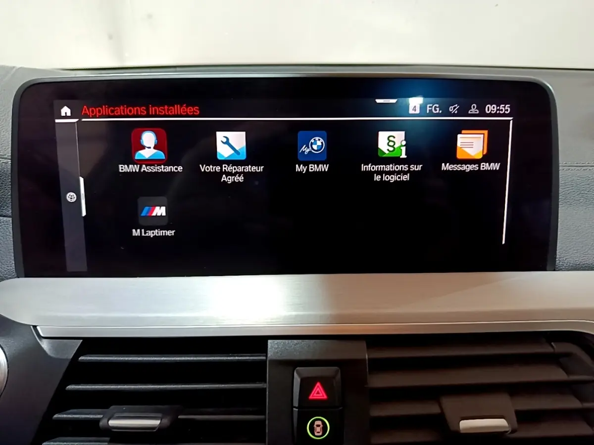 Écran tactile central affichant les applications installées dans l’habitacle d’un BMW X3 noir, vue de face.