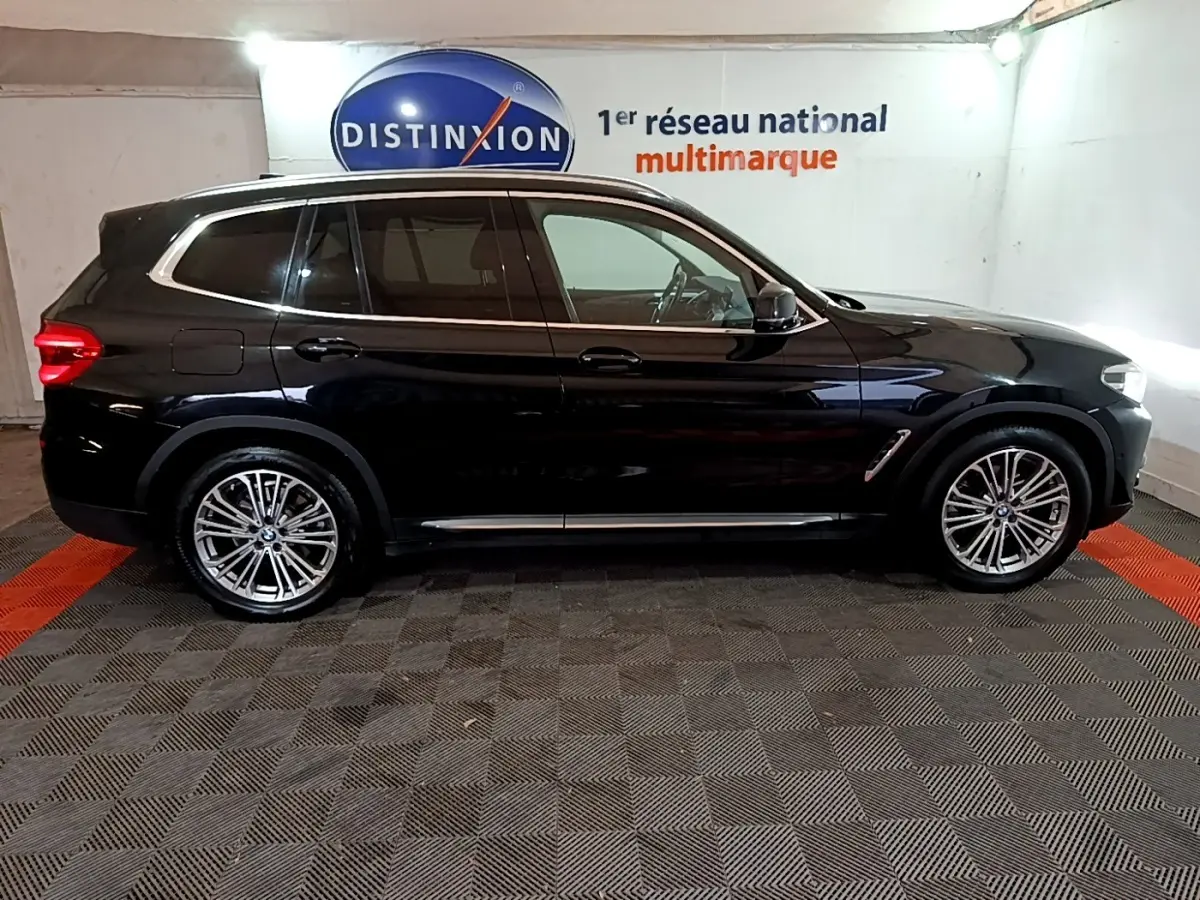 BMW X3 sDrive18d noir vue de profil côté gauche, avec jantes alliage et rails de toit chromés visibles.
