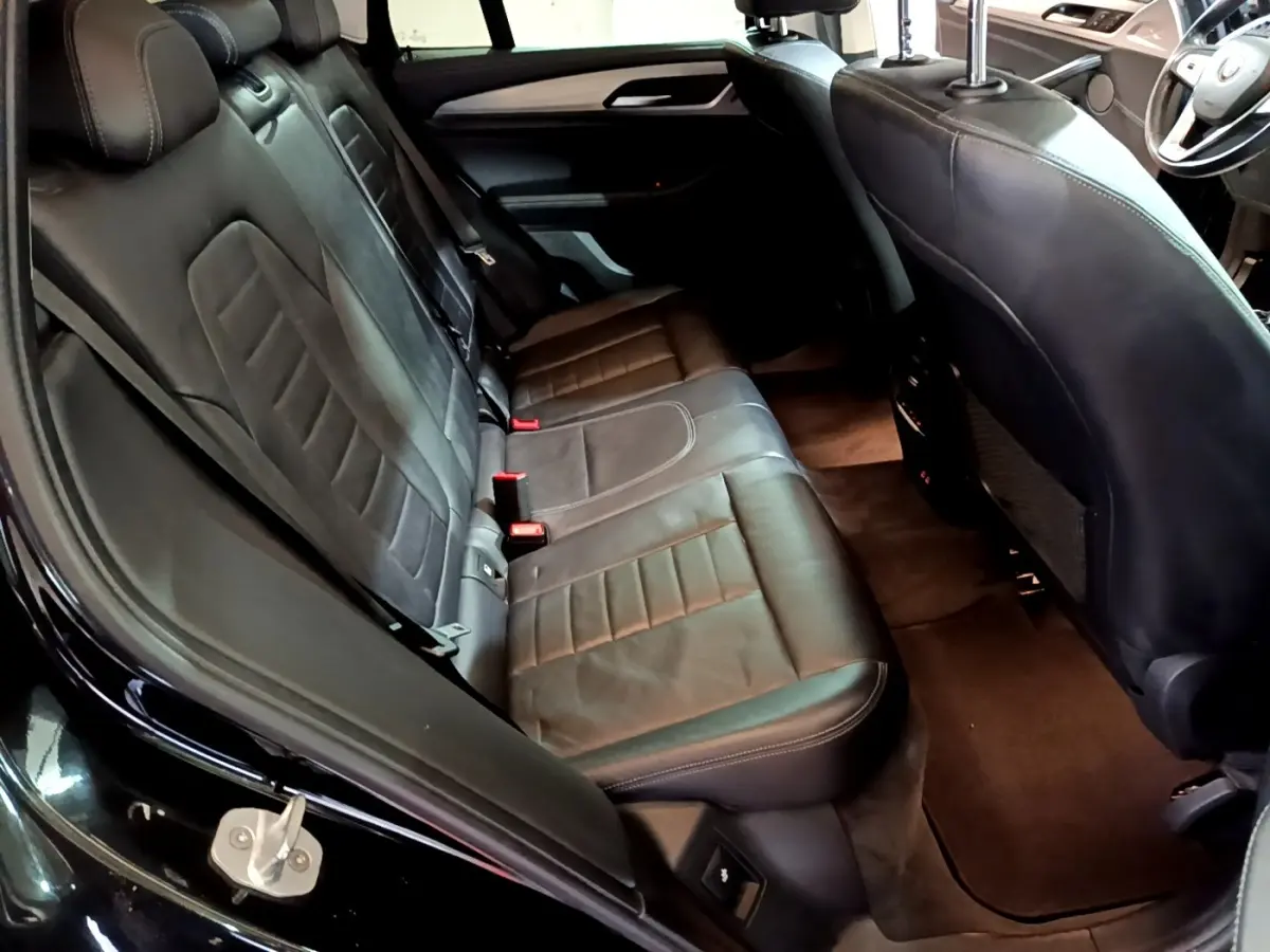 Vue intérieure montrant la banquette arrière en cuir noir d’une BMW X3 sDrive18d 2019, côté gauche ouvert.