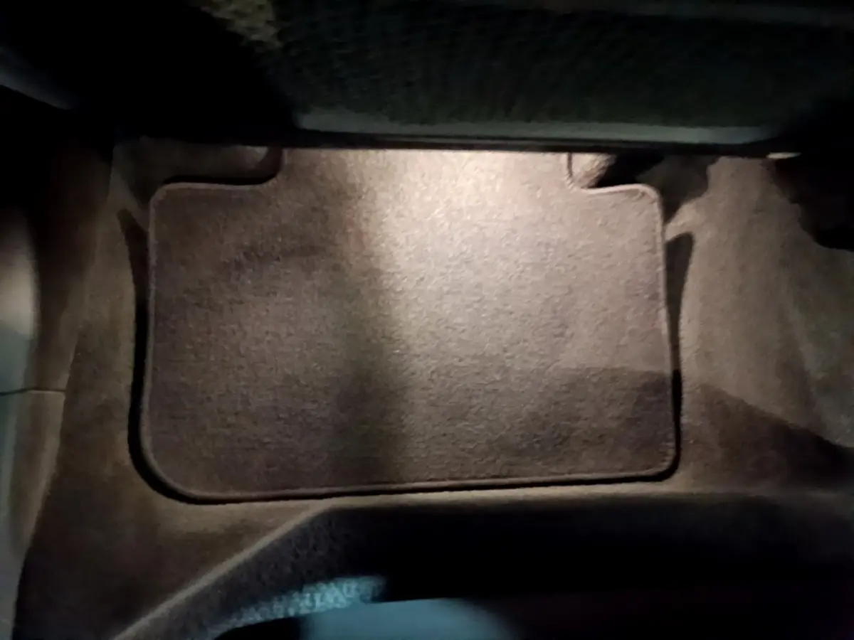 Tapis de sol noir dans l'habitacle avant d'une BMW X3 sDrive18d 2019, vue en plongée rapprochée.