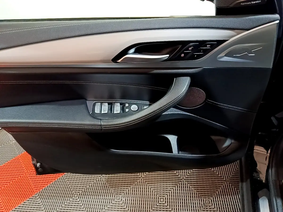 Vue intérieure côté gauche de la porte BMW X3 sDrive18d 2019 noire, avec commandes électriques et insert aluminium.