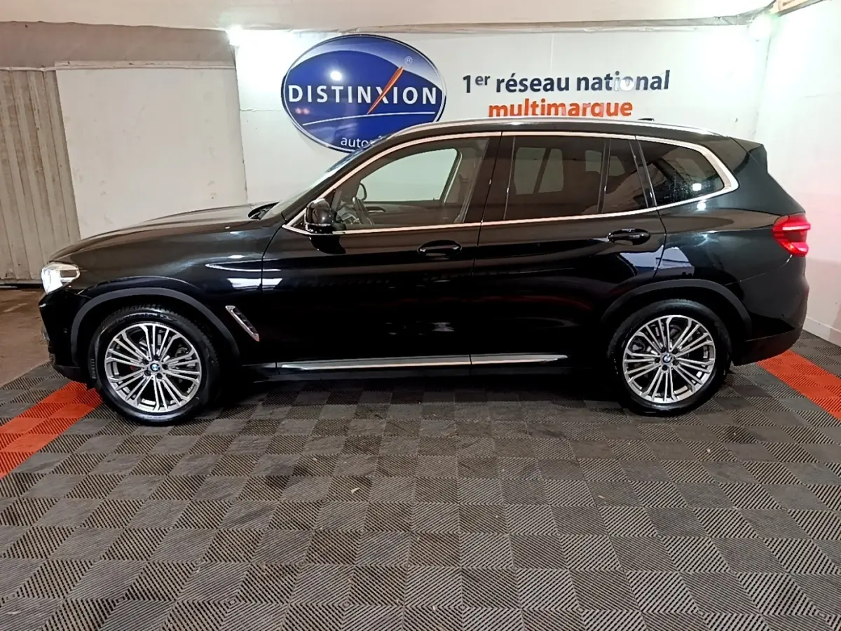 BMW X3 sDrive18d noir vu de profil côté gauche, avec jantes alliage et rails de toit chromés visibles.