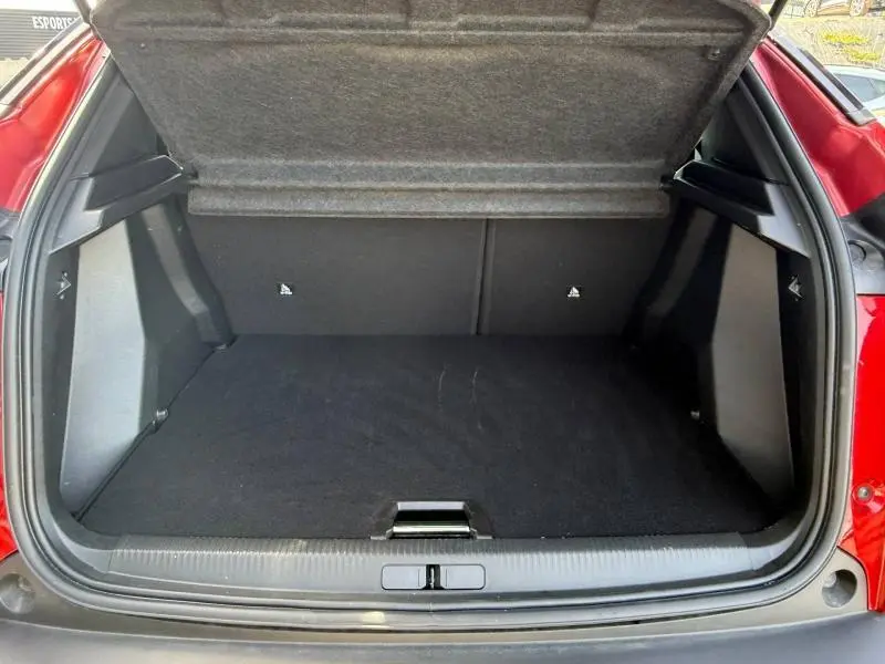 Coffre ouvert vu de l'arrière d'un Peugeot 2008 Rouge Elixir 2025, montrant l'espace de chargement vide.