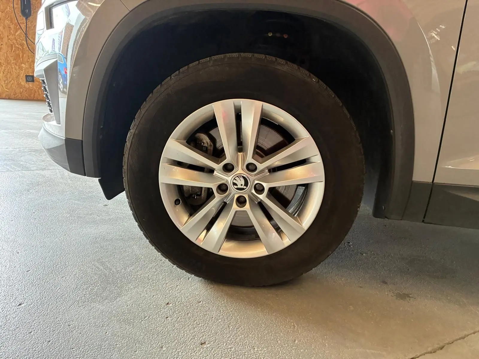 Gros plan sur la roue avant droite d’un Skoda Kodiaq gris clair, mettant en valeur la jante alliage à plusieurs branches.