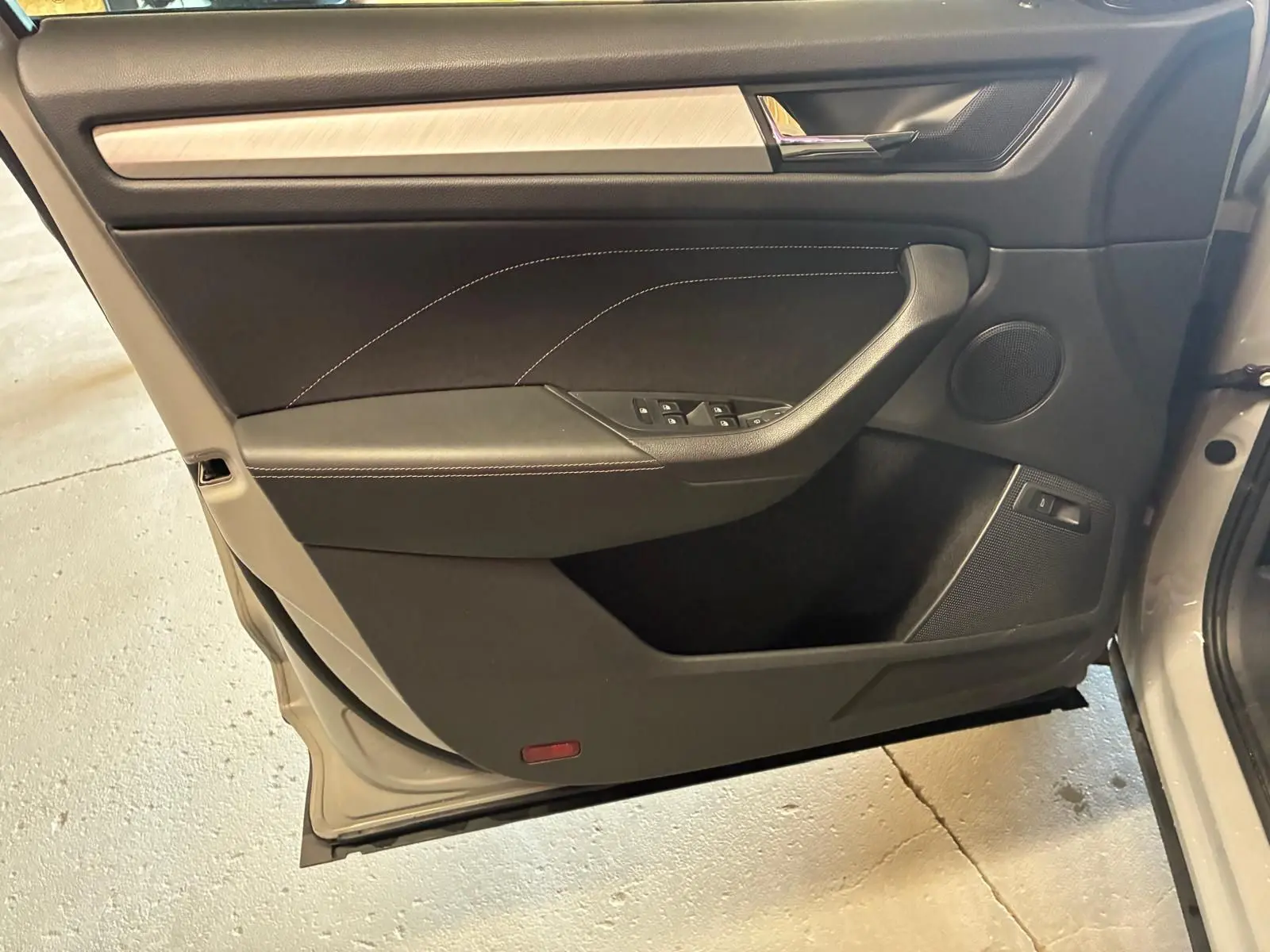 Vue rapprochée de la porte avant gauche du Skoda Kodiaq gris clair, avec garniture noire et insert bois clair.