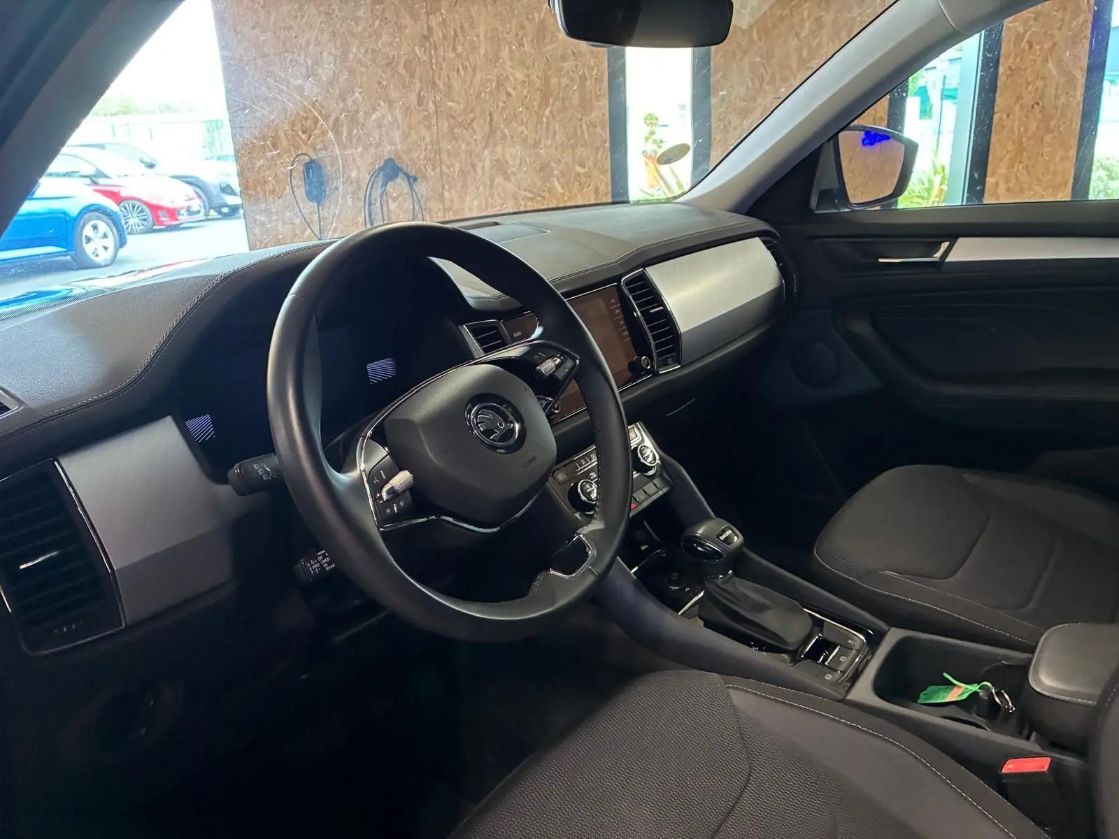 Intérieur noir du Skoda Kodiaq 2023, vue côté conducteur montrant volant, tableau de bord et console centrale.