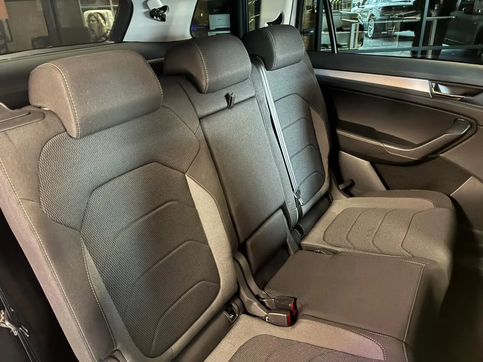 Vue intérieure sur la banquette arrière en tissu noir du Skoda Kodiaq 2023, avec ceinture et habillage de porte visible.