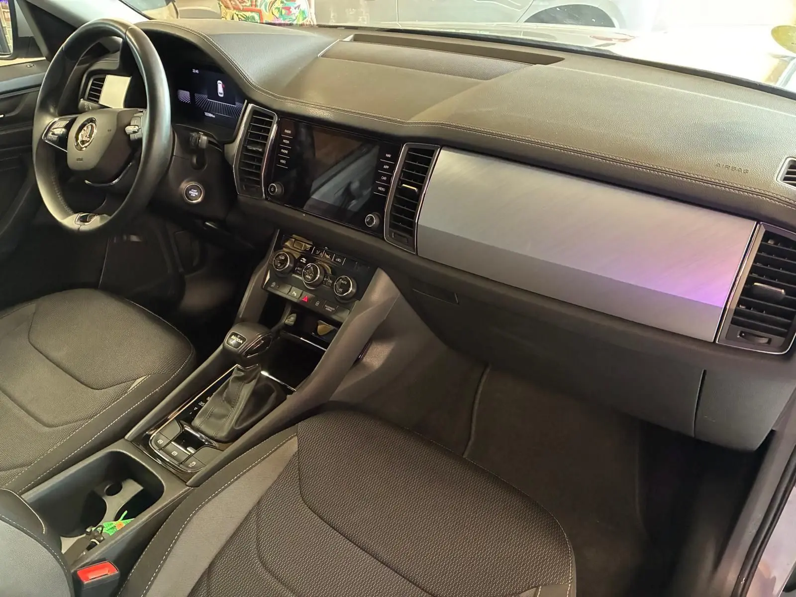 Intérieur noir du Skoda Kodiaq 2023, vue côté conducteur, tableau de bord moderne avec écran tactile et console centrale.