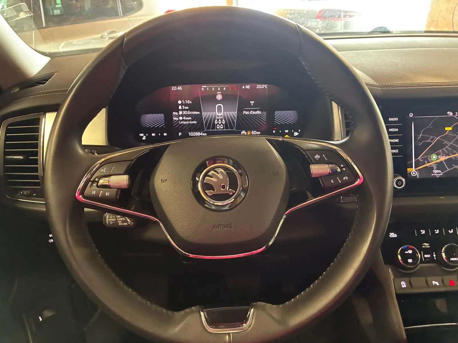 Vue rapprochée du volant noir du Skoda Kodiaq 2023 avec tableau de bord digital et écran central tactile allumé.