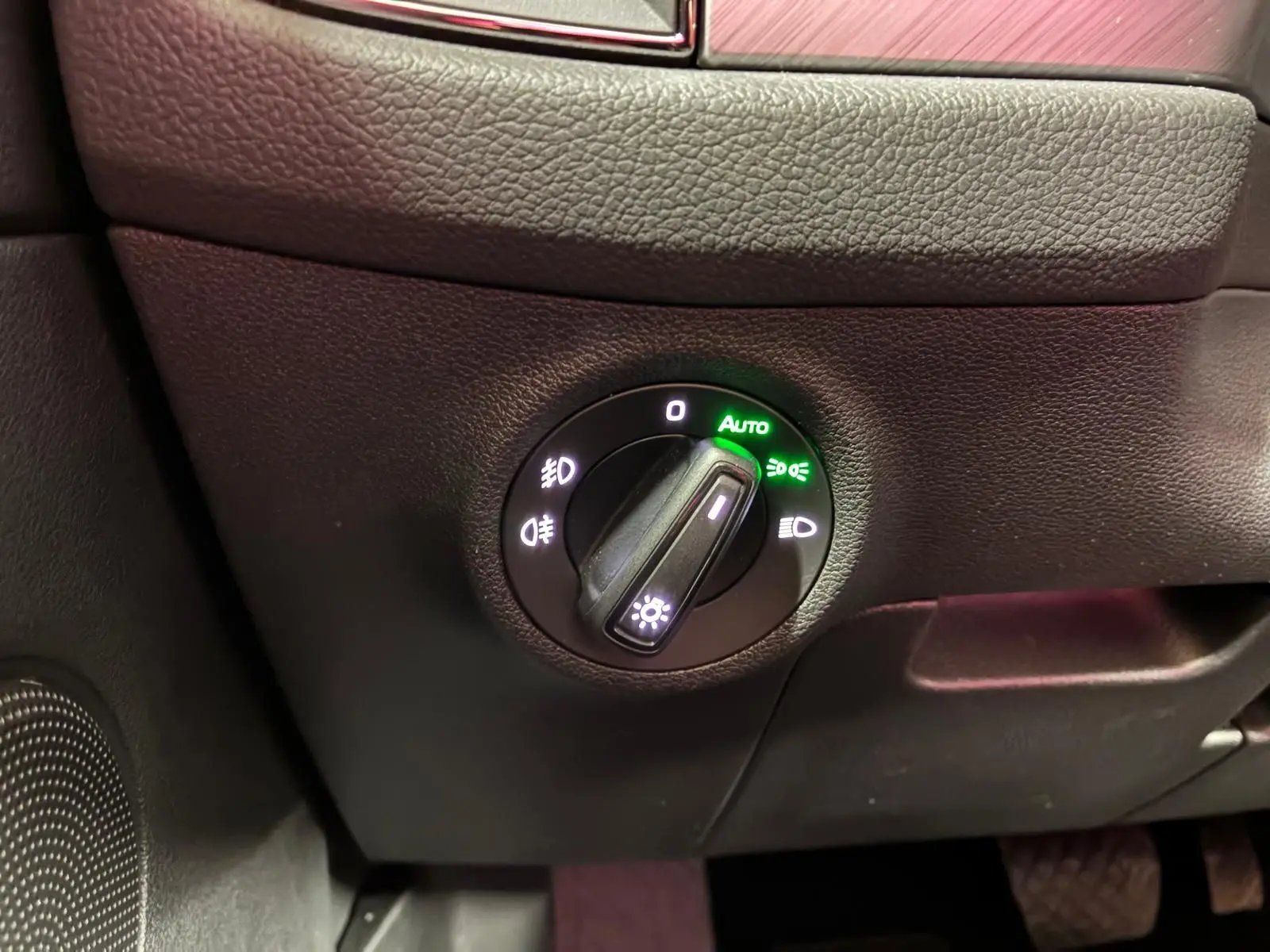 Gros plan sur le bouton de commande des phares du Skoda Kodiaq gris clair, éclairage automatique activé.