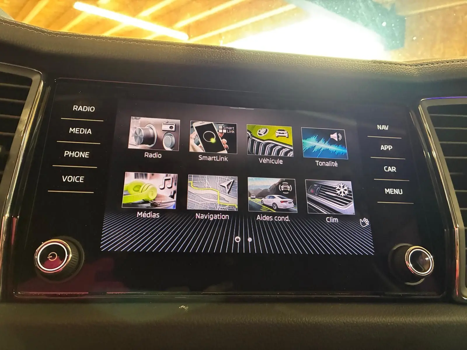 Écran tactile central du Skoda Kodiaq gris clair 2023, affichant le menu principal avec options multimédia et navigation.