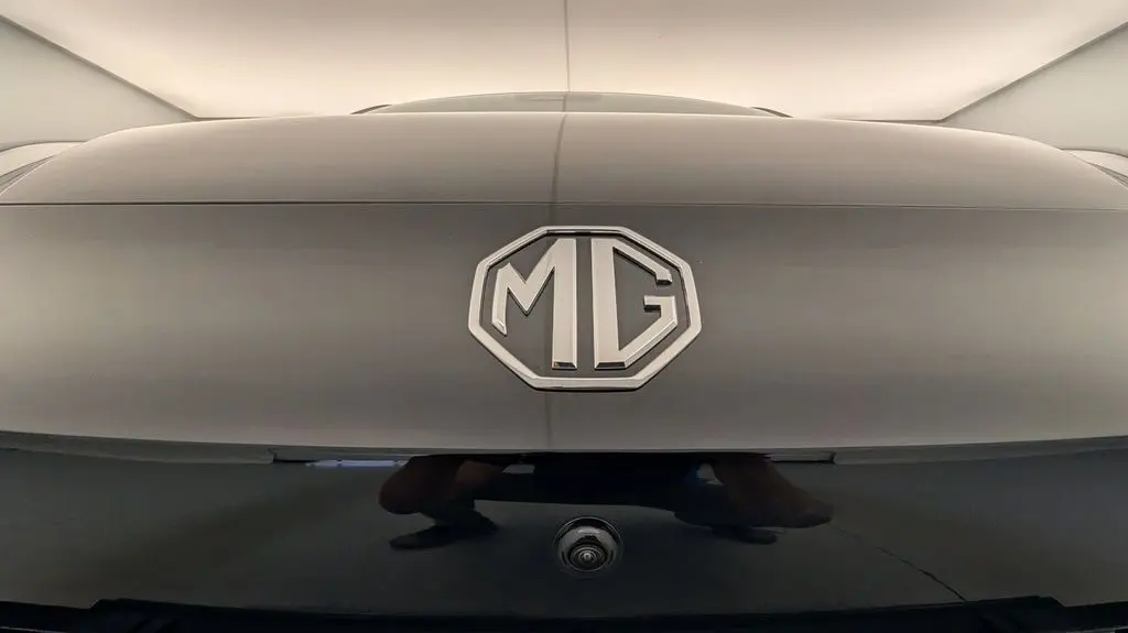 Gros plan sur le logo MG en relief sur la malle arrière noire Pebble Black avec caméra de recul intégrée.