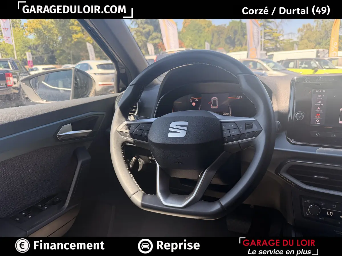 Vue intérieure centrée sur le volant cuir noir et le tableau de bord digital d'une SEAT Arona 2025.